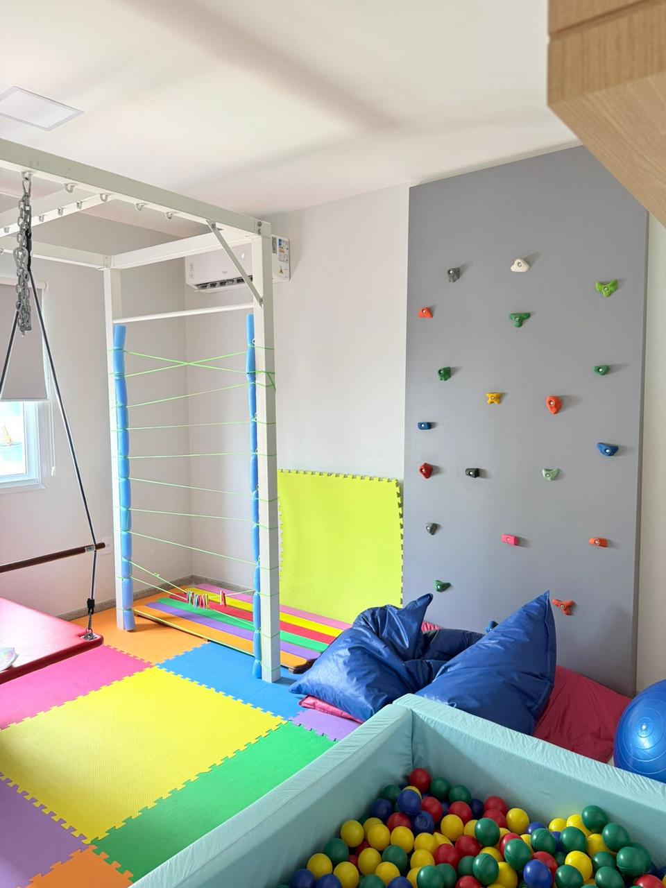 Espaço terapêutico infantil com equipamentos e piscina de bolinhas